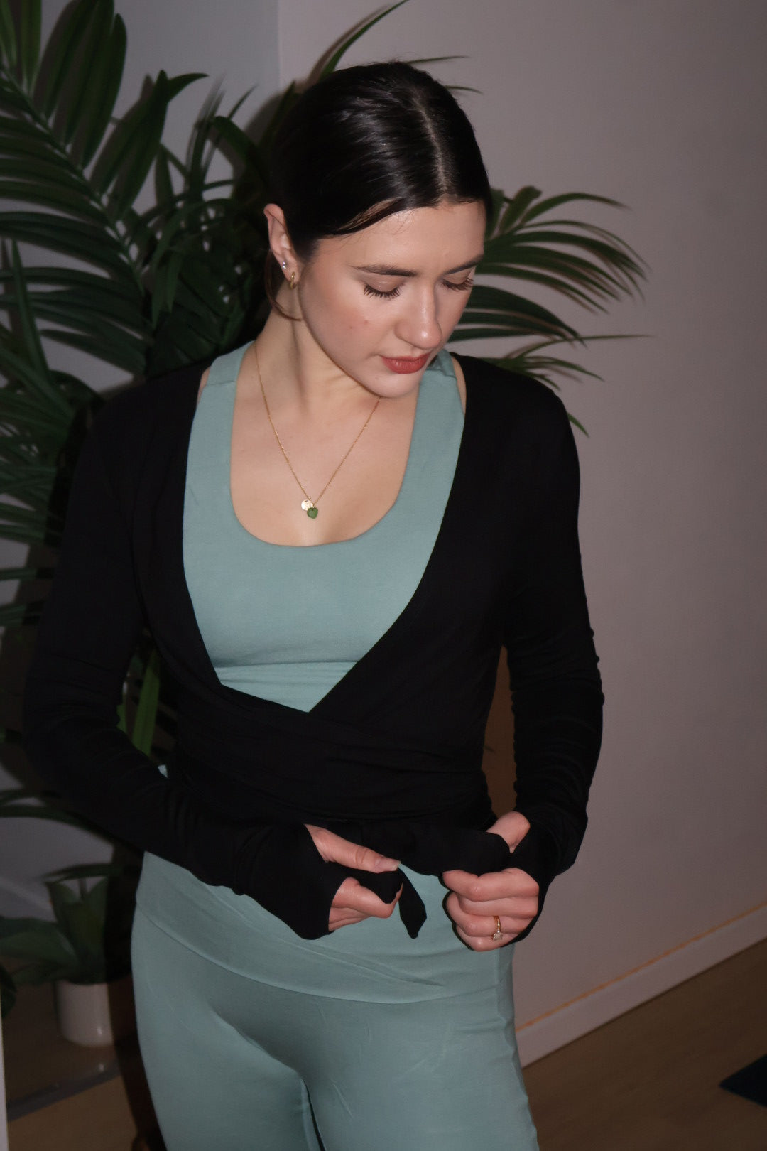 woman wearing black wrap top tying it