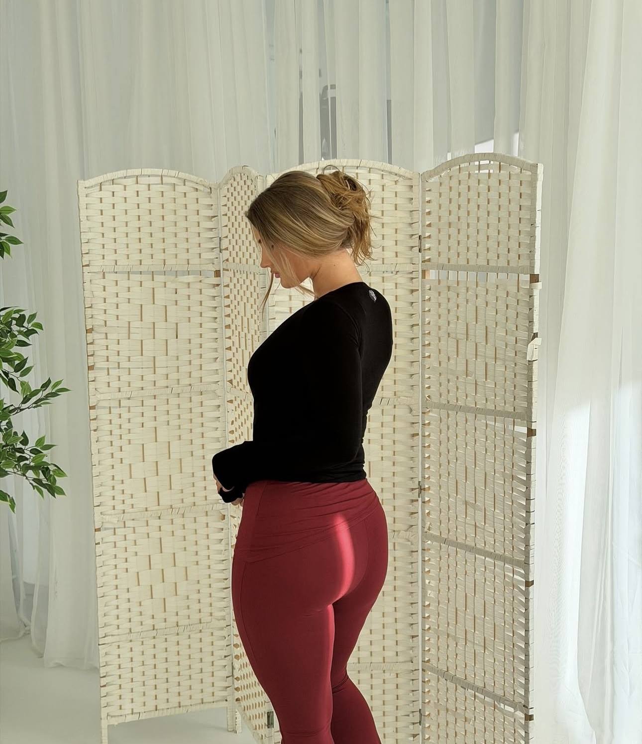 Woman wearing Willoma bamboo activewear featuring the Bamboo Wrap Cardigan and Mabel Leggings in rich burgundy, crafted from premium breathable bamboo fabric.